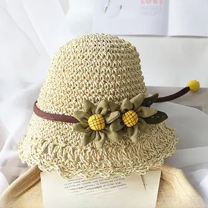 Détail du chapeau de soleil en paille tressée avec tournesols en tissu et bord festonné