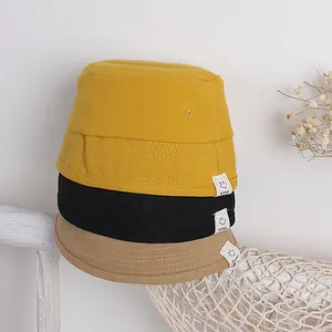 Kinder Fischerhut mit Smiley-Patch in Gelb, Schwarz und Khaki auf Holzständer