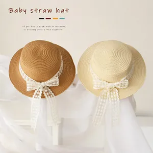 Detailed texture of baby straw hats with elegant lace bows and flat brim design