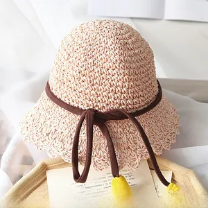 Détail d'un chapeau en paille tissé main avec bords ondulés ajourés et lien décoratif