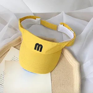 Detail of yellow canvas visor for kids with m embroidery and white sweatband inside