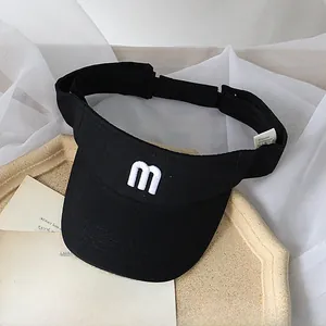 Detail view of black sun visor with white embroidered letter m and adjustable back strap