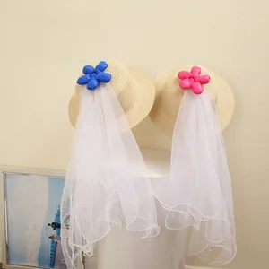 Detail of baby straw hats with colorful 3D floral accents and long white mesh veils