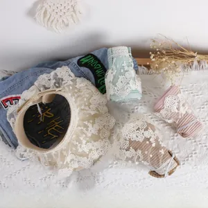 Detail of children's straw hats featuring wide floral lace brims in four pastel colors
