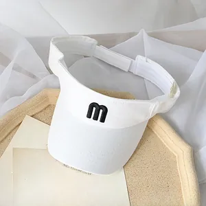 White sun visor for kids with embroidered letter M and adjustable velcro strap close-up
