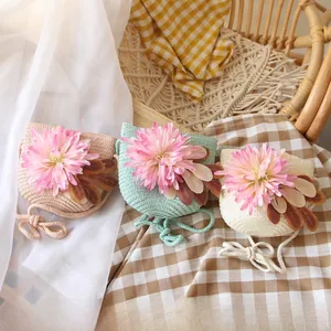 Detail of woven straw bags for girls with pink floral decor in various soft colors