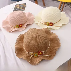 Detailed texture of woven straw sun hats with floral ornaments and wavy scalloped brims
