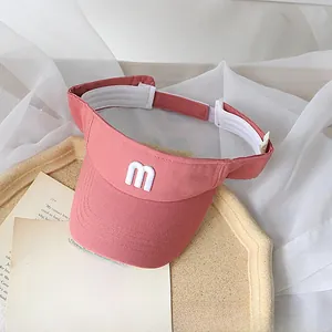 Detail of coral pink kids sun visor with 3D letter embroidery and adjustable strap