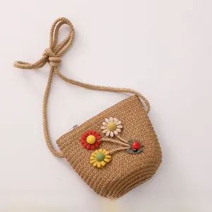 Detailed view of handmade straw crossbody bag with colorful crochet flowers and ladybug decor