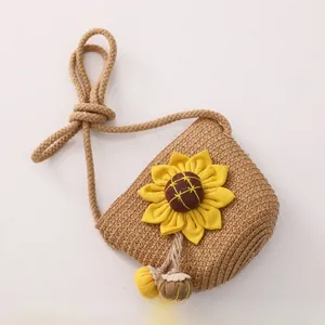 Detail of hand-woven straw crossbody bag with 3D yellow sunflower and soft cotton rope strap