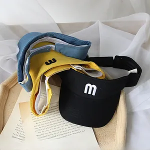 Detail of adjustable sun visors in black, yellow, and blue with embroidered M letter