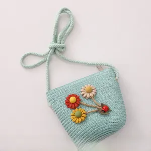 Detailed view of mint green straw bag for kids with 3D floral accents and ladybug charm