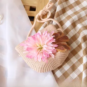 Detail of a handmade straw mini crossbody bag with a pink gradient flower and rope strap