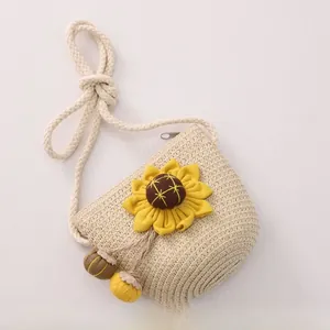 Close-up of girls sunflower straw shoulder bag with zipper and colorful pompom charms