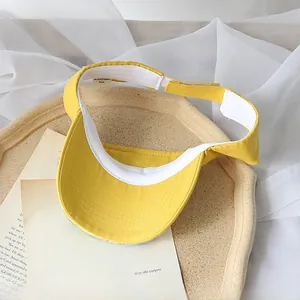 Detail of children's sun visor showing yellow fabric texture and adjustable velcro strap