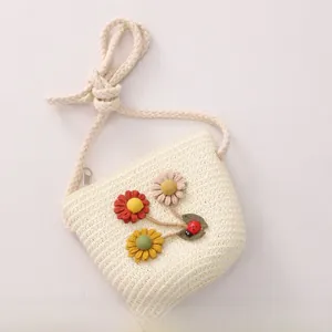 Close-up of children's straw crossbody bag with floral accents and ladybug detail