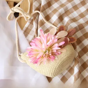 Close-up of girls straw crossbody bag with gradient pink flower on woven texture