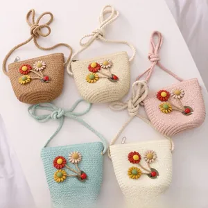 Detail view of woven straw crossbody bags with floral accents and ladybug ornaments