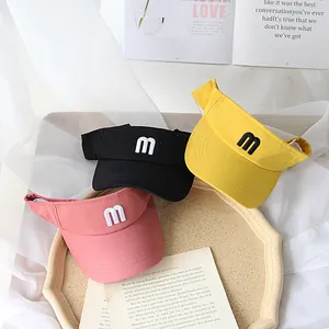 Kids sun visor hats in black, yellow, and pink with embroidered letter m detail