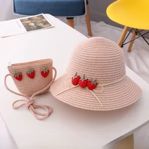 Détail du chapeau de soleil en paille et sac fraise assorti en rose tendre