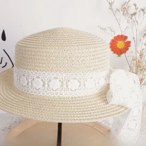 Detail of children's straw hat with white floral lace ribbon and elegant bow accent