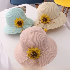 Detailed view of woven straw sun hats in green, beige, and pink with sunflower accents
