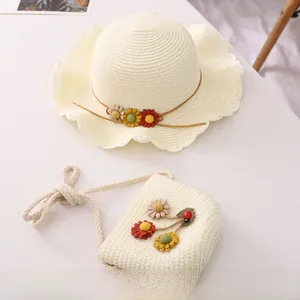 Detail of cream straw hat and matching bag set with colorful floral weave decorations