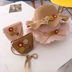 Detail of woven straw sun hat and matching crossbody bag with 3D floral daisy decorations
