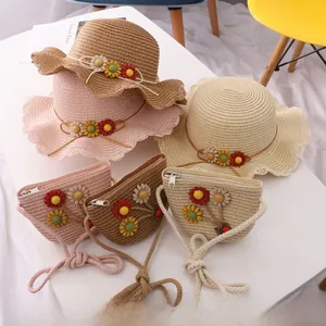 Detailed view of woven straw sun hat and matching floral crossbody bag for children