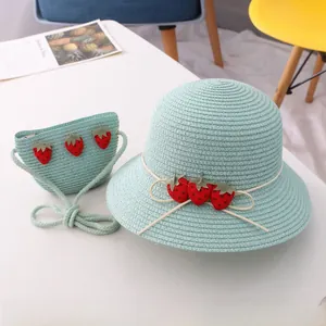 Détail de l'ensemble chapeau de paille vert menthe et sac avec écussons fraises