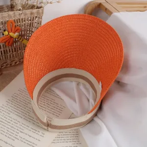Detailed texture of orange woven straw sun hat with striped edge for kids' summer protection