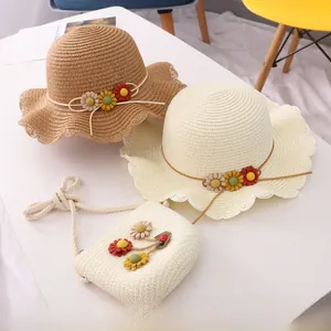 Close-up of woven straw sun hat with wavy petal edges and handmade daisy decorations