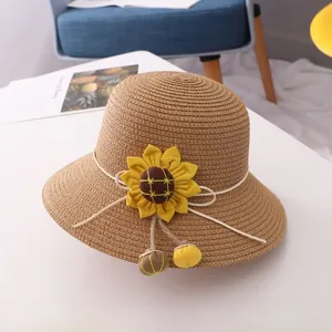 Detail view of children straw sun hat with sunflower ornament and woven texture