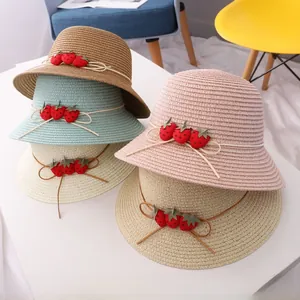 Détail de chapeaux de paille pour filles avec fraises décoratives en quatre couleurs