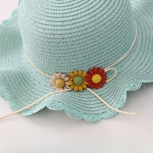 Detailed view of handmade woven straw hat with sunflower accents and wavy brim edge