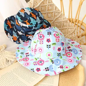Spring children's sun hat with shark and flower patterns in a cozy wooden tray setting