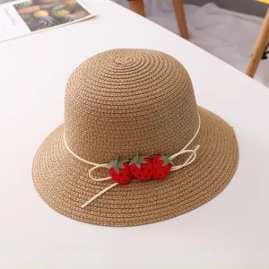 Détail d'un chapeau de paille orné de fraises rouges 3D décoratives pour filles