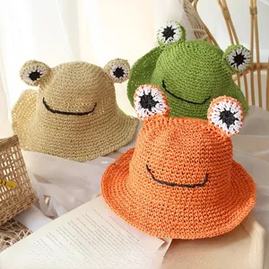 Detailed texture of hand-woven straw frog sun hats in khaki green and orange