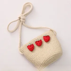 Vue détaillée du sac bandoulière en paille pour filles avec écussons fraises décoratifs