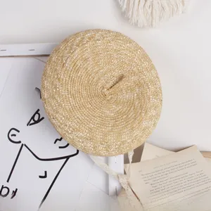 Detailed close-up of straw beret hat with delicate white lace ribbons for summer sun protection