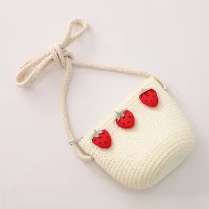 Détail d'un sac bandoulière crème pour enfant avec fraises et bandoulière en corde de coton
