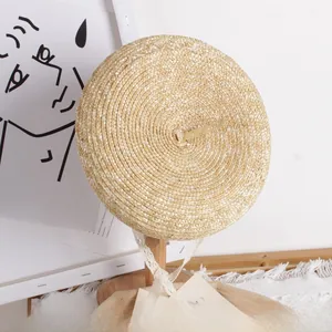 Detail of handwoven straw beret with white lace ribbons on a wooden display stand