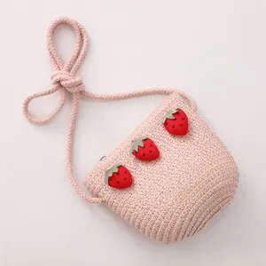 Détail d'un sac bandoulière en paille rose avec appliques de fraises mignonnes pour filles