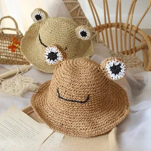 Detailed view of handmade woven frog straw hats in beige and khaki for summer sun protection