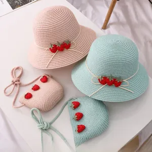 Détail du chapeau de paille tissé et du sac fraise assorti pour fille en tons pastels