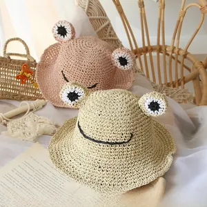 Detailed close-up of handmade crochet frog hats for kids in soft pink and beige colors