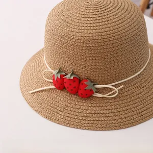 Gros plan sur la texture d'un chapeau de paille tissé avec de jolis accessoires fraises