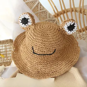 Detail of handwoven straw hat for kids with frog eyes and a windproof adjustable chin strap