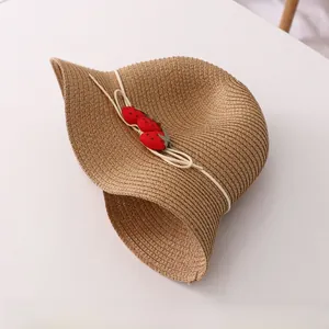 Détail d'un chapeau de soleil en paille tissée pour fille avec motifs fraises et bord ondulé