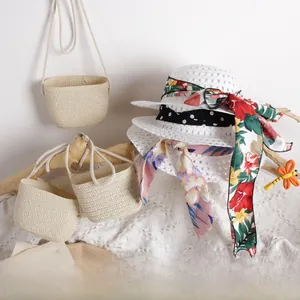 Detailed view of kids breathable hollow straw hat and matching bag with floral ribbons